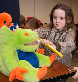 A kindergarten student practices brushing teeth during a visit to the SIU School of Dental Medicine.