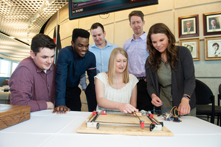 SIUE School of Engineering senior Elise Rainey sits by the Robo-Checkers board she and her teammates created.