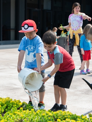 William and Isaac from the SIUE ECC help maintain the rooftop garden on campus by water flowers.