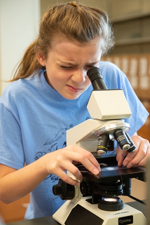 Sophie Uder, of Edwardsville, uses a microscope to view evidence.