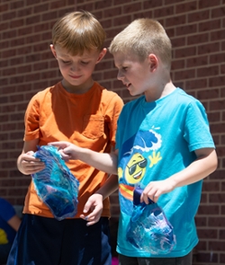 Henry Samet, of Edwardsville, (left) and Caleb Peksa, of Troy, examine each other’s animal mask creations during the drying process.