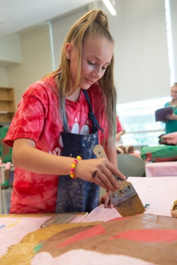 Brooke Geggus, of Edwardsville, paints her papier mache pop art creation.