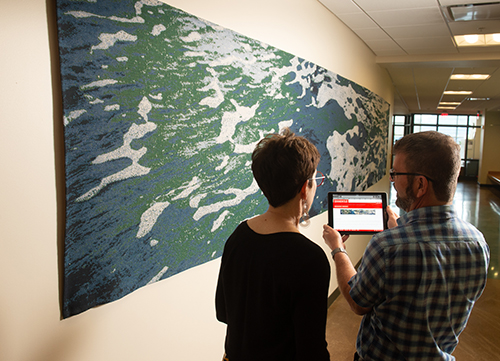 Viewing a jacquard weaving by Professor Laura Strand which reimages seafoam along the Florida coastline, University Museum Executive Curator Erin Vigneau-Dimick and Associate Professor Dave Jennings learn more about the piece’s scientific connection using the web-based application. 