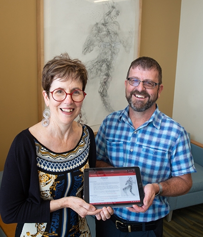 (L-R) University Museum Executive Curator Erin Vigneau-Dimick and Associate Professor Dave Jennings have launched the AISLE project which connects individuals to the scientific connection of selected artworks installed throughout SIUE’s Science West and Science East. Arboreal Anatomy by professor Brigham Dimick is featured in the background.