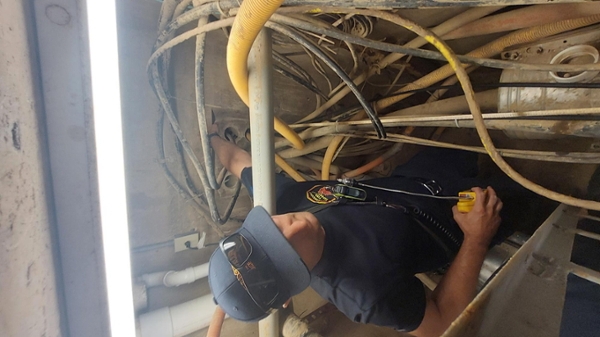 Man in a confined space surrounded by cables